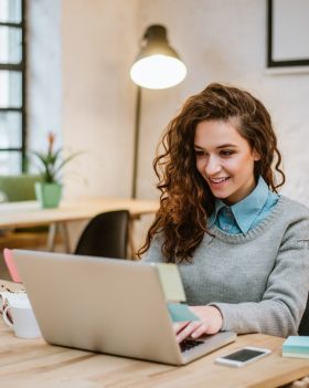 Successful young woman in modern office working on laptop.